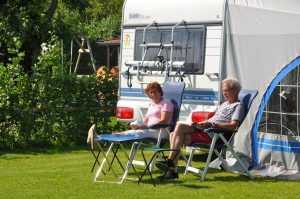 Twee mensen op stoelen voor een caravan op een kleine campings noord holland