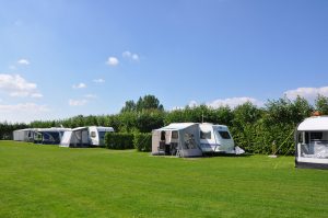 Witte caravans op een groen veld op de kleine campings noord holland