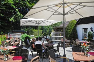 Het terras met parasollen op de natuurcamping gelderland