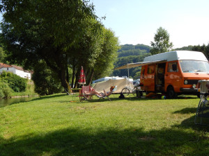 Een oranje campervan op de kleine camping in Luxemburg