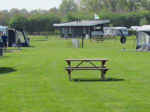 Een picknicktafel in het gras op de kleine camping in Gelderland