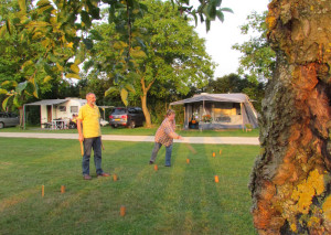 Mensen spelen Kubb op de boerencamping in Brabant
