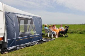 Mensen aan tafel in het gras op de kleine camping Friesland