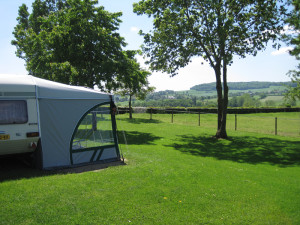 Een caravan op het groene veld van de kleine camping Limburg