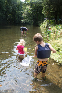 Kinderen vissen met kleine netjes in de rivier bij de kleine camping Luxemburg