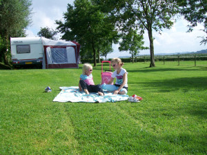 Meisje op een kleedje in de zon op de kleine camping Limburg