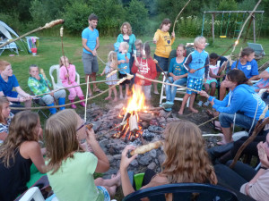 Kinderen bakken brood rondom een kampvuur op de kleine camping Luxemburg