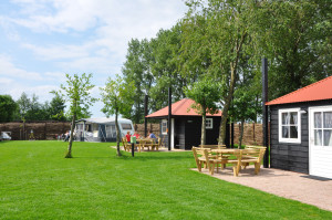 Zwarte houten chalets op de boerencamping Overijssel
