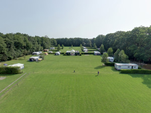 Een luchtfoto van het groene grasveld van de boerencamping Overijssel