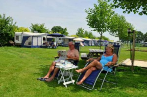 En koppel zit in blauwe campingstoelen op de kleine camping Drenthe