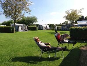 Zonnen in een stoel op het gras op de kleine camping Limburg