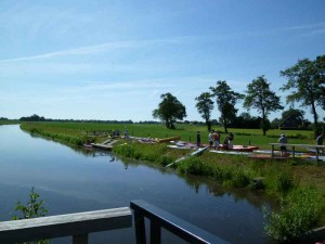 Mensen met kano's staan naast de sloot bij Struiken en een deel van de kleine camping Overijssel