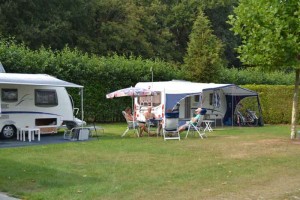 Caravans en mensen in campingstoelen op de natuurcamping Limburg
