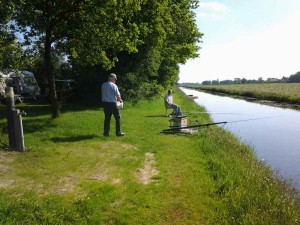 Mannen vissen aan het water op de kleine camping Overijssel