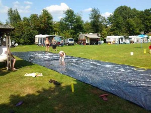 Een glijbaan van zeil met zeepsop op de kleine camping Overijssel