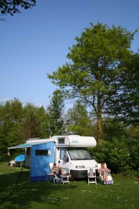 Een stel zit voor de camper op een kleine camping in Gelderland