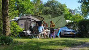 Een gezin voor de caravan op een boerencamping
