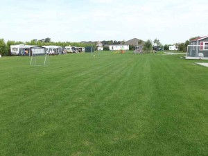 Het grote grasveld op de kleine camping Zeeland