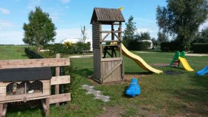 De speeltoestellen en het konijnenhok op de boerencamping Utrecht