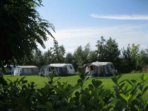 Drie caravans op het grasveld van de boerencamping Gelderland