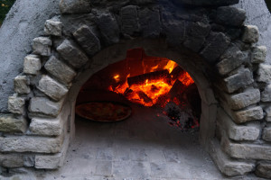 Een houtoven met een pizza op de boerencamping brabant