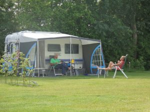 Een caravan met kamperende mensen op de natuurcamping zuid holland