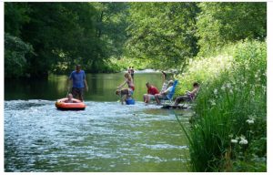 Mensen en kinderen spelenin de rivier bij de boerencamping