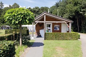 Bomen en een houten gebouw op de camping