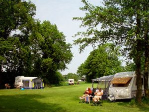 Het kampeerveld met tenten en caravans. Te boeken met de camping card